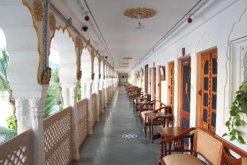 a corridor of a building with chairs and tables at Hotel Pushkar Palace in Pushkar
