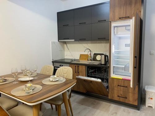 a kitchen with a table with chairs and a refrigerator at Ulcinj Apartments in Ulcinj