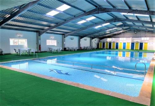 a large indoor swimming pool with blue water at 200 Breakaway Chalet in Scratby
