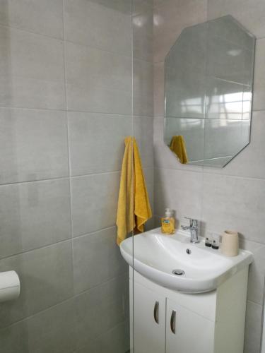 Baño blanco con lavabo y espejo en Bee Comfy, en Klein-Brakrivier