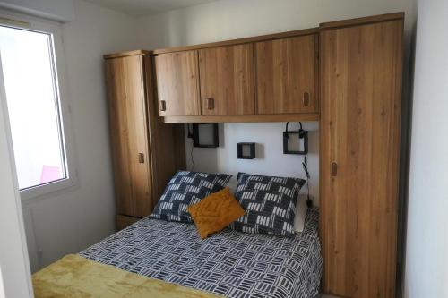 - une petite chambre avec un lit et une armoire en bois dans l'établissement Vue port et mer, centre-ville, au calme, garage, à Sète