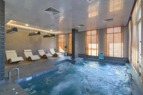 a pool in a room with a large room with at Aquamarine - Beach & SPA Hotel- All inclusive in Kranevo