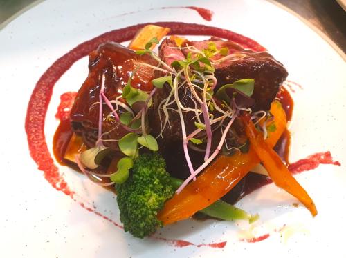 a white plate of food with carrots and broccoli at Ratanui Lodge in Pohara