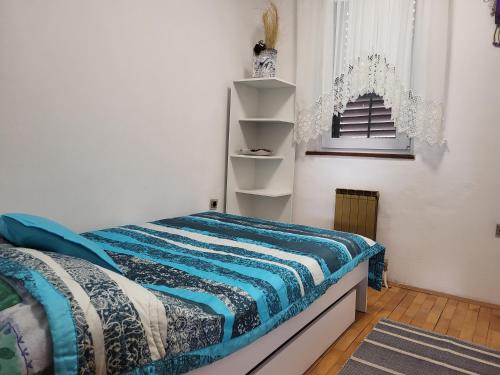 Schlafzimmer mit einem Bett mit blauer Decke in der Unterkunft Apartmaji Ri-100 in Portorož