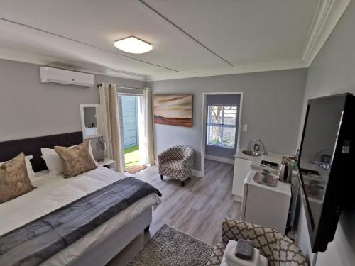 ein Schlafzimmer mit einem Bett und einem Schreibtisch in einem Zimmer in der Unterkunft Huis van Brood Guesthouse in Malmesbury