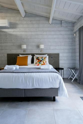 une chambre avec un grand lit dans une pièce dans l'établissement Le Mas des Oliviers Nîmes, à Nîmes