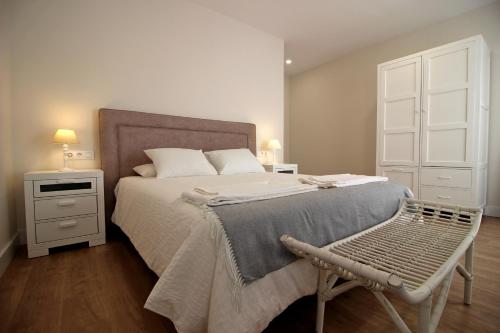 ein Schlafzimmer mit einem großen Bett und einem Stuhl in der Unterkunft Casa Verata in Losar de la Vera