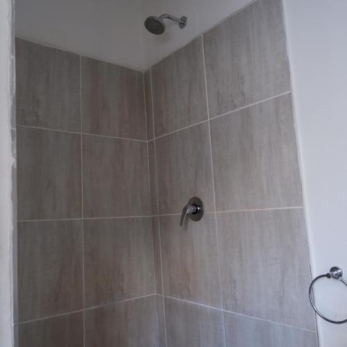 a shower with a brown tiled wall at The City Club in Cape Town