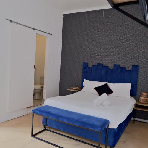 a bed with a blue headboard in a room at The City Club in Cape Town