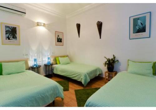 Zimmer mit 2 Betten und grüner Bettwäsche in der Unterkunft L'AUBERGE DE TENNIS MSC in Marrakesch