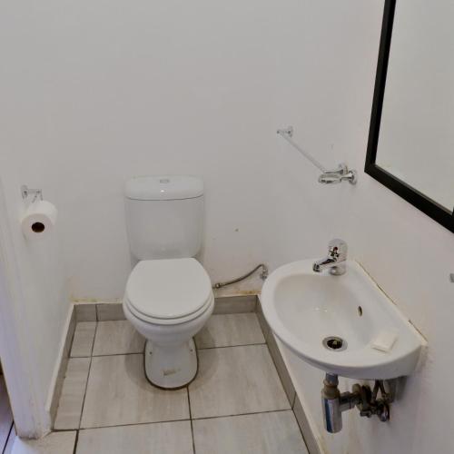 a white bathroom with a toilet and a sink at The City Club in Cape Town