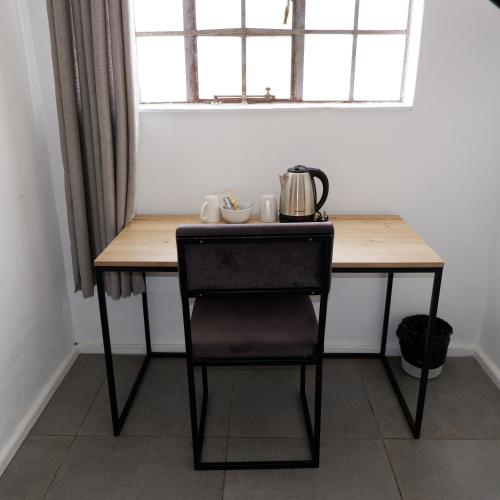 a table with a chair in a room with a window at The City Club in Cape Town