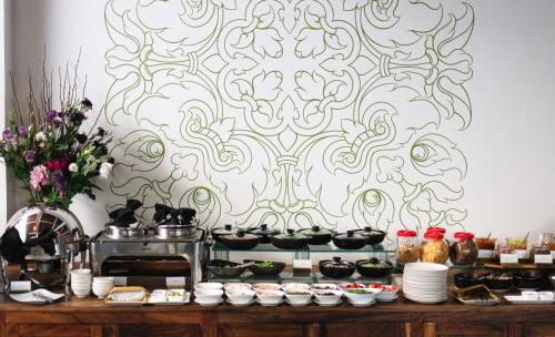 a table with food on it with a patterned wall at Plantation Urban Resort & Spa in Phnom Penh