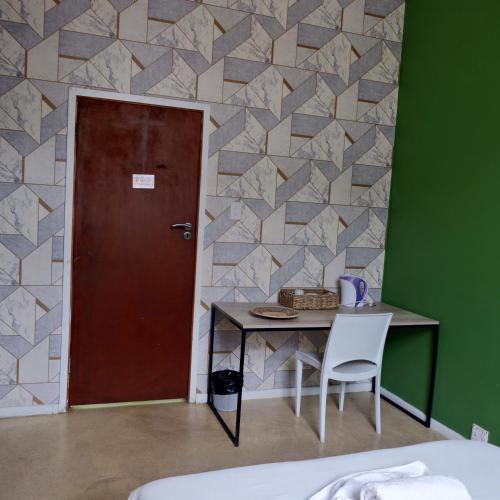 a room with a table and a door and a table and chair at The City Club in Cape Town
