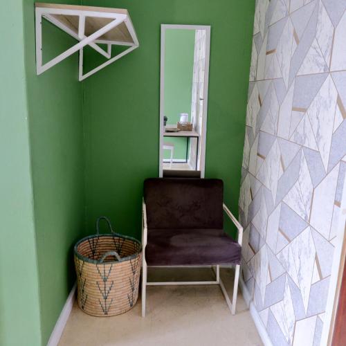 a green room with a chair and a mirror at The City Club in Cape Town