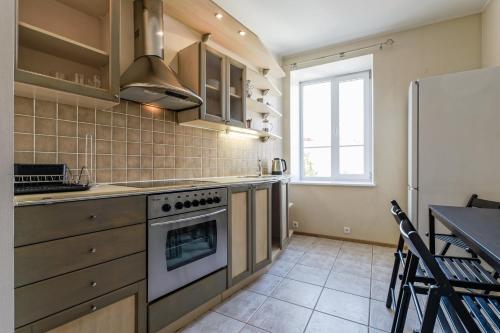 a kitchen with a stove and a refrigerator at Old Town - Viru Apartment in Tallinn