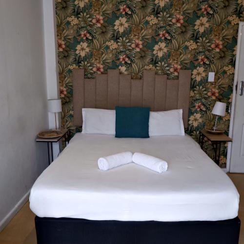 a bed with a headboard and a white bedspread at The City Club in Cape Town