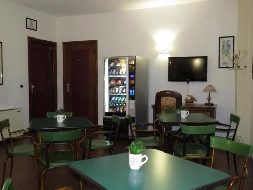 a restaurant with tables and chairs and a television at Hotel San Michele in Aprilia