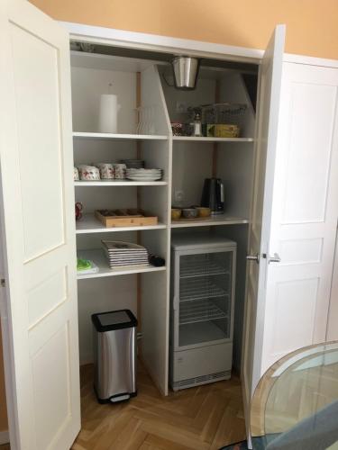 a kitchen with a pantry with a refrigerator in it at Chez Ghislaine et Robert 