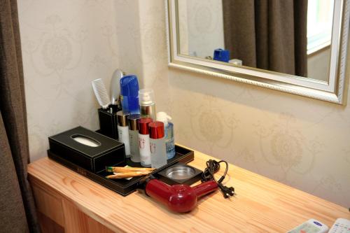 a bathroom counter with a bottle of alcohol and a toaster at Traum Hotel & Condo in Gapyeong