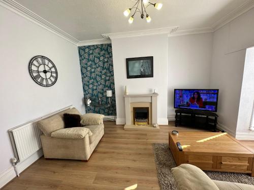 a living room with a tv and a couch and a table at Spacious one bedroom apartment in central location in Lytham St Annes