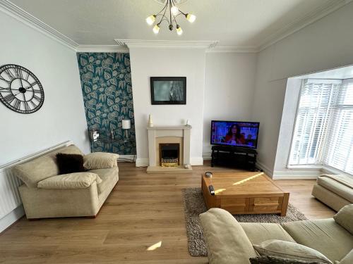 a living room with a couch and a tv at Spacious one bedroom apartment in central location in Lytham St Annes