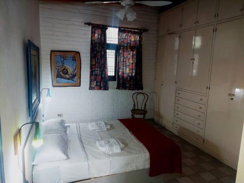 1 dormitorio con cama blanca y manta roja en La Tranquilidad Soñada en Mendoza
