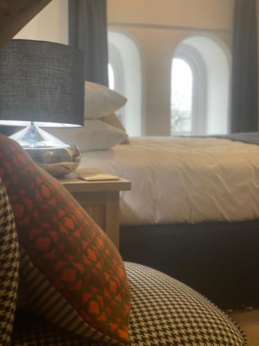 a bedroom with a bed and a table with a lamp at Caemorgan Mansion in Cardigan