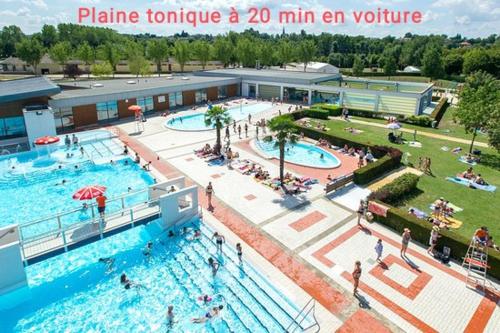 - une grande piscine avec des personnes séjournant dans un complexe dans l'établissement La p'tite des Got, à Viriat