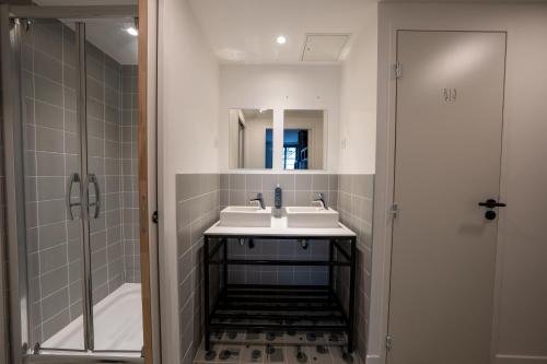 a bathroom with two sinks and a shower at Beau M Paris in Paris