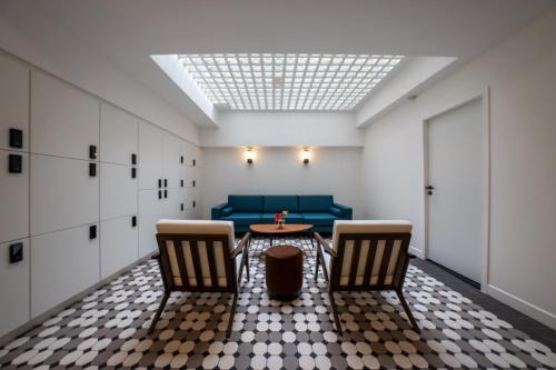 a room with a couch and a table and chairs at Beau M Paris in Paris