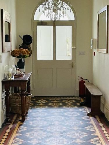 a hallway with a door with a chandelier at Caemorgan Mansion in Cardigan