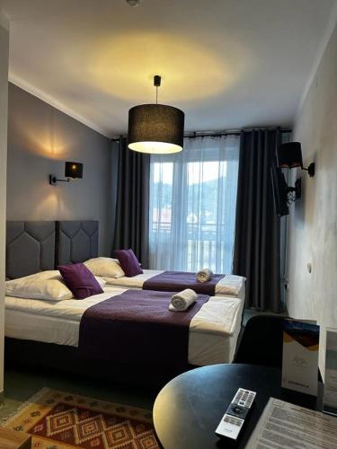 a bedroom with two beds and a large window at WRZOS resort & wellness in Węgierska Górka