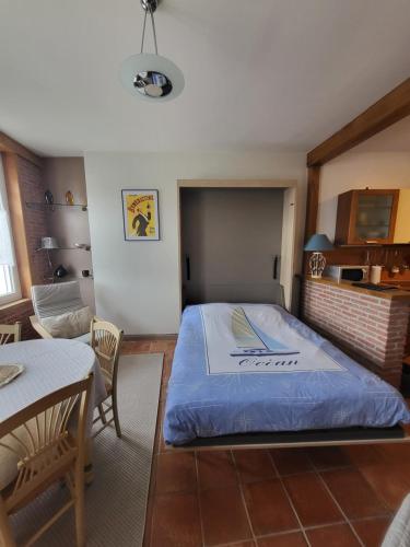 une chambre avec un grand lit et une table dans l'établissement Quai Babord, à Fécamp