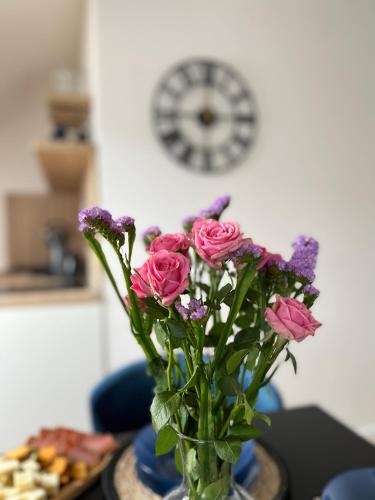 a vase filled with pink flowers on a table at Loft apart Pluzine in Pluzine