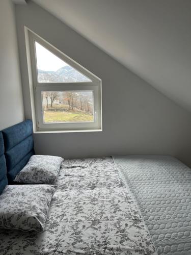 um quarto com uma cama e uma janela em Loft apart Pluzine em Pluzine
