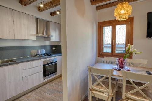 uma cozinha com uma pequena mesa e uma sala de jantar em Ecco Suites Apartments em Veneza