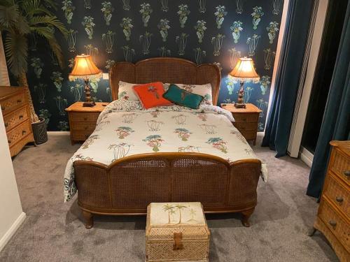 um quarto com uma cama com duas mesas de cabeceira e dois candeeiros em Palm View Luxury Botanical Themed apartment with sauna em St Austell