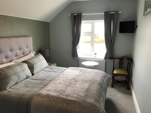 ein Schlafzimmer mit einem großen Bett und einem Fenster in der Unterkunft Kielty's of Kerry Bed and Breakfast in Waterville
