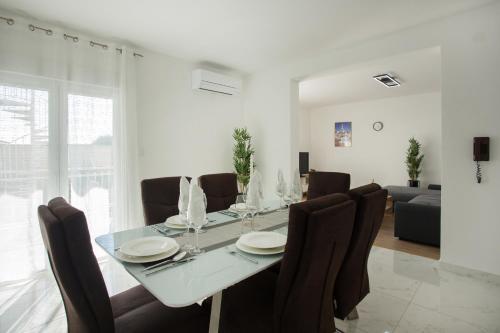uma sala de jantar branca com uma mesa e cadeiras em Apartment Radman em Split