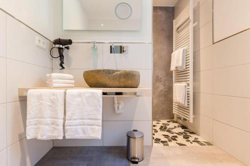 a bathroom with a sink and towels on a shelf at Haus Felsberg in Niedersalwey