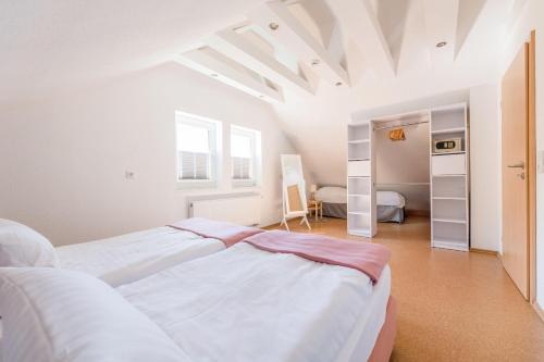 1 dormitorio blanco con 2 camas y ventana en Haus Felsberg, en Niedersalwey