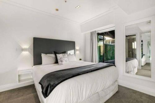 ein weißes Schlafzimmer mit einem großen Bett und einem Fenster in der Unterkunft THE VIADUCT WATERFRONT LUXURY - Views & Location! in Auckland