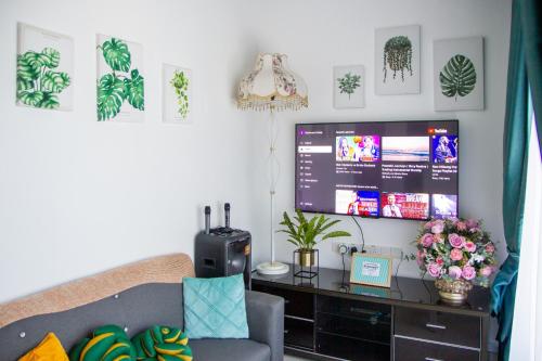 ein Wohnzimmer mit einem Sofa und einem Großbild-TV in der Unterkunft Just Stay Inn Guest House in Malakka