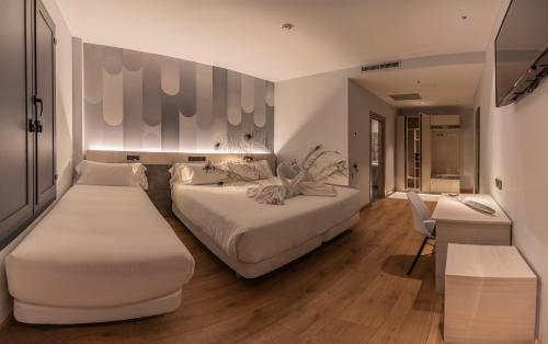 Habitación de hotel con 2 camas y sofá en Hotel NERU con Encanto, en León