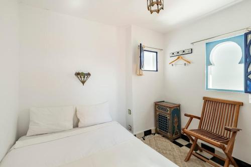 een slaapkamer met een bed, een stoel en een raam bij DAR YAMNA Maison typique Kasbah de Tanger in Tanger