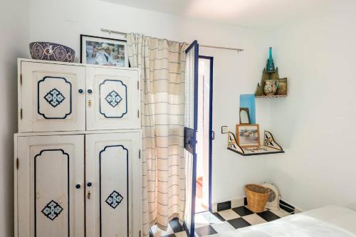 a bedroom with a white cabinet and a checkered floor at DAR YAMNA Maison typique Kasbah de Tanger in Tangier
