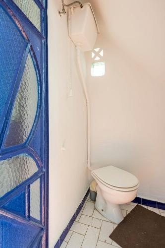 a bathroom with a toilet and a blue door at DAR YAMNA Maison typique Kasbah de Tanger in Tangier
