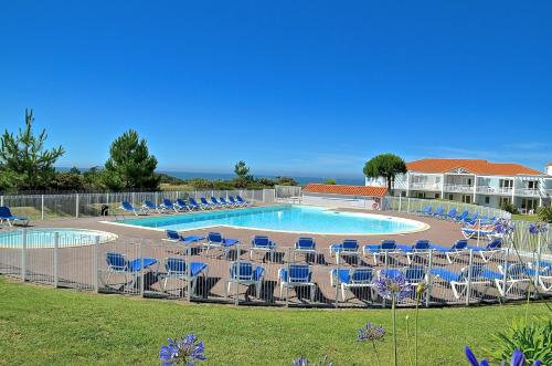 a swimming pool with blue chairs at Appartement 2 pièces dans résidence bord de mer aux Sables d'Olonne in Les Sables-d'Olonne