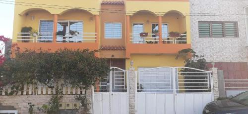 dom z białym płotem przed nim w obiekcie Casa Kyara T0 w mieście Praia